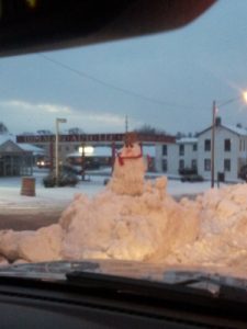 Business owners making snowmen in piles of snow in the middle of the road! There were several.