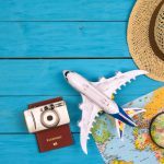 A toy plane, hat, and passport on a map