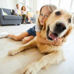 A young girl hugging her dog