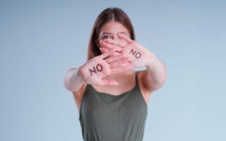 woman with "no" written on both hands