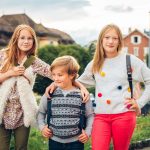 Group of 3 kids with backpacks, 2 schoolgirls and one preschooler, back to school concept