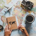 Map of the world with a camera, coffee up, and more on top