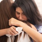 Sad woman hugging her friend