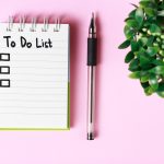 A to-do list with a pen on a pink desk