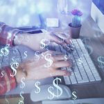 A man typing on a keyboard with dollar signs superimposed