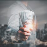 A woman in a business suit holding cash