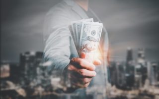 A woman in a business suit holding cash