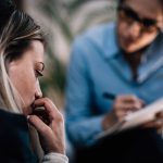 woman being listened to by a woman with a notebook