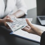 Employee being handed cash across a desk