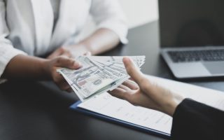 Employee being handed cash across a desk