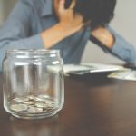 stressed man with coins in a jar