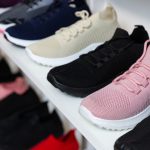A row of mulit-colored sneakers on a shelf