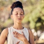 Yoga, meditation and fitness with a black woman breathing for calm exercise outdoor in a nature park. Wellness, health and meditate with a female yogi finding peace, balance or zen alone outside