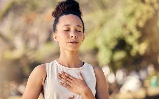 Yoga, meditation and fitness with a black woman breathing for calm exercise outdoor in a nature park. Wellness, health and meditate with a female yogi finding peace, balance or zen alone outside