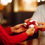 A husband givint a small gift to his wife