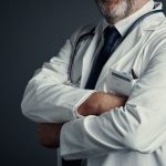 A doctor in a white coat and crossed arms