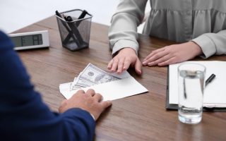 Bank teller giving money in an envelope to a customer