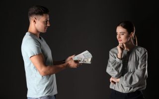 A man handing over cash to his girlfriend