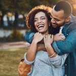 A happy couple hugging each other and smiling