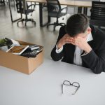 A depressed man at his desk after being fired