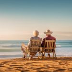 Elderly couple sitting on chairs on the beach at the day time