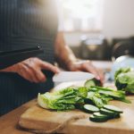 Hands, tablet and salad recipe in kitchen with help, support and teaching at home for healthy food. People cooking lunch on digital tech for nutrition tips with lettuce, cucumber and green vegetables.