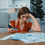 Stressed woman looking at her bills and credit card
