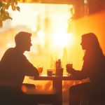 Man and woman sitting across the table from each other in the sun