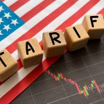 Word Tariff made with wood toy blocks on financial tables. Business concept