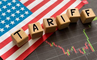 Word Tariff made with wood toy blocks on financial tables. Business concept