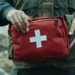 A man holding a Red Cross bag