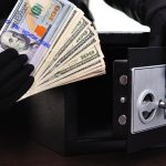 Thief stealing money from a safe