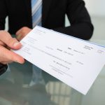 A man handing over a paycheck