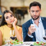 Man and woman on a dinner date and the woman looks bored