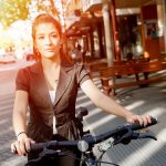 A young woman riding a bike in the street
