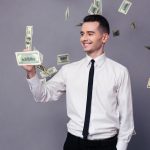 A young millionair holding a dollar bill