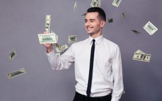 A young millionair holding a dollar bill