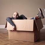 A man sitting in a cardboard box