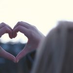Woman holding up a heart sign with her hands