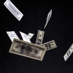 $100 bills falling in front of a black background