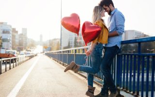 A couple in love with a pair of heart balloons