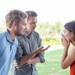 two male friends talking to a female friend