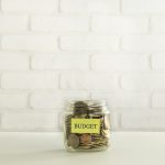 A jar filled with coins and a small sign that says 