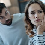 An unhappy woman looking away from her boyfriend