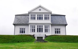 A mansion on a green grassy hill