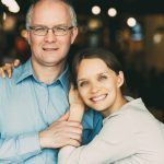 Smiling adult daughter with his father