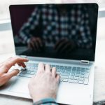 Hands typing on a laptop keyboard