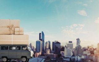 A truck with moving boxes and a city in the background