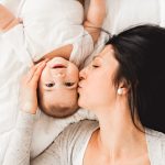 A woman with a baby on bed at home