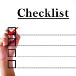 Businessman hand checking mark on checklist with marker over white.
